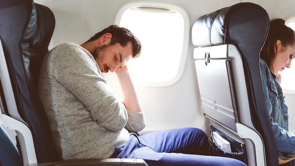 hombre durmiendo en avión
